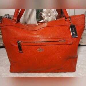 Coach Tyler Tote in an orange/red shade of pebbled leather.